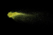 Freeze motion of yellow powder explosions isolated on black background