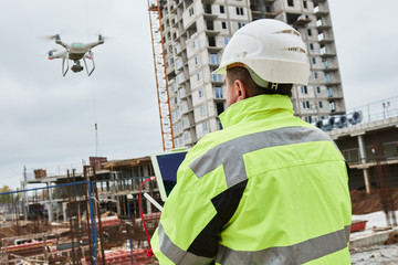 Wall Mural - drone operated by construction worker on building site