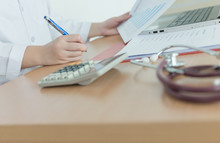 Health Care Costs Concept Picture : Hand Of Female Doctor Used A Calculator For Medical Costs. Stethoscope And Calculator On A Medical Chart ,symbol For Health Care Costs Or Medical Insurance.
