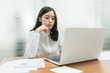 © chompoo - Young business woman working on laptop in office.