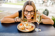 © rh2010 - Young woman enjoying tasty appetizer with pinchos, traditional spanish snack, and glass of wine sitting outdoors at the bar in Valencia city