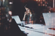© SFIO CRACHO - Young woman working at night modern office loft.Blurred background.Horizontal. Flares and reflections effects.