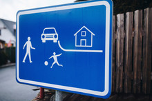 Blue Street Sign With Kids, House And Car On It