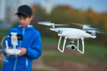 Wall Mural - young man operating of flying drone at sunset