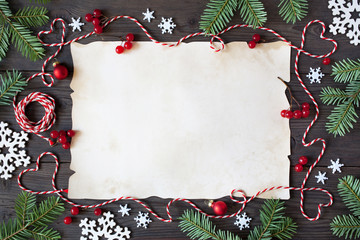 Christmas wooden background with paper, snowflakes, branches tree, red berries and twine in the form of hearts