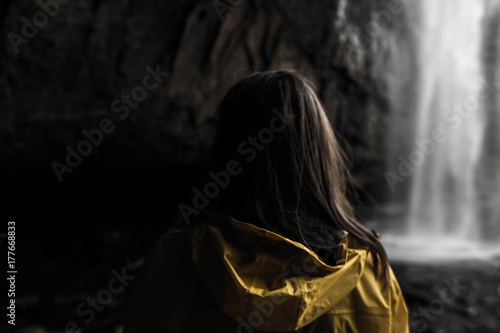 Plakat Dziewczyna w płaszczu przeciwdeszczowym w wodospadzie