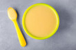 © Africa Studio - Bowl and spoon with baby porridge on table