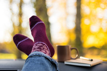 Autumn Car Trip. Woman Feet In Warm Wool Socks And Cup Of Tea In The Car