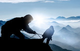 Fototapeta Sypialnia - Hilfe beim Aufstieg - Bergsteiger auf einem Gipfel im Hochgebirge 