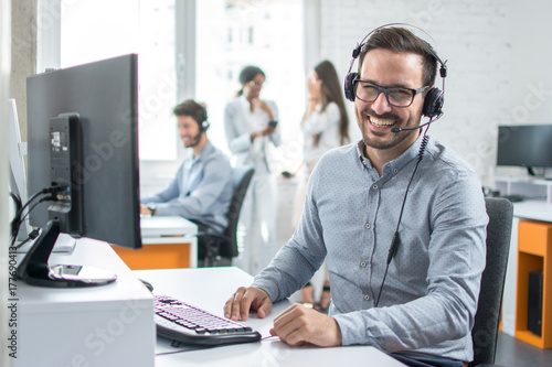 Fotografía Happy young male customer support executive working in office.