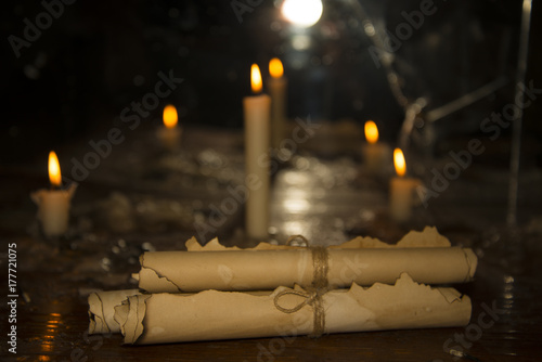 Fotografering Mysterious ancient scrolls on the table with candles.