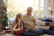 © Jacob Lund - Little girl and grandfather by christmas tree with tablet pc