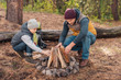 © LIGHTFIELD STUDIOS - Father and son kindling bonfire