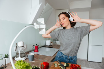 Wall Mural - Portrait of a cheery young woman listening to music