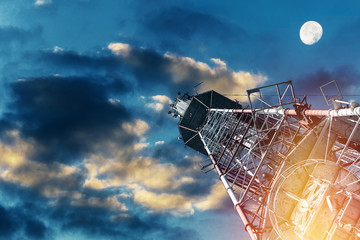 Telecommunications tower against blue sky, in red and white