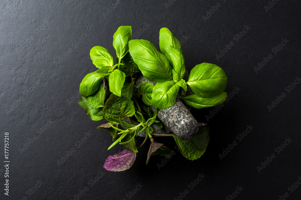 Fresh herbs inside of stone mortar with pestle - obrazy, fototapety, plakaty 