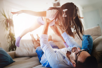 Wall Mural - Portrait of father and daughter playing at home