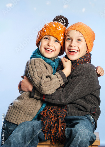 Fotografia, Obraz Small Series of two Bothers with orange hats in Winter Snow Background: Hapiness