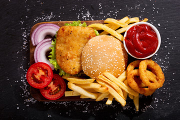 Wall Mural - chicken burger with french fries and onion rings, top view