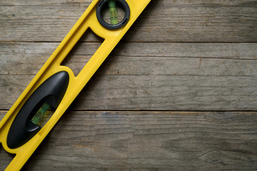 Wall Mural - Yellow building level on the old wood table, engineering work tool concept