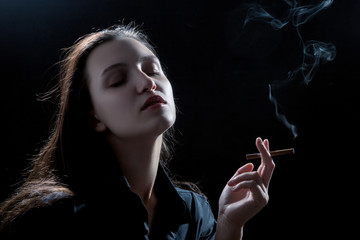 Wall Mural - beautiful woman smoking cigarette on black background