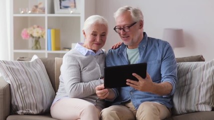 Poster - senior couple having video chat on tablet pc