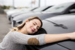 © Louis-Paul Photo - Jolly young female driver hugging her new car