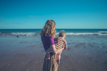 Wall Mural - Mothre on beach holding her baby boy