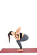© Vittaya_25 - young asian woman doing yoga in Revolved Chair asana yoga pose, Parivrtta Utkatasana pose on the mat isolated on white background, exercise fitness, sport training, healthy lifestyle, people concept