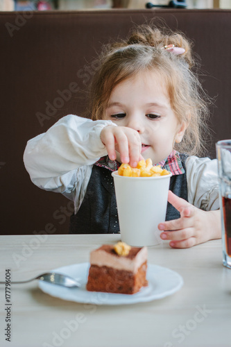 Plakat Małej dziewczynki łasowania francuz smaży na restauraci.