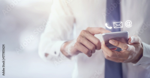 Fotografía CONTACT US, Hand of Businessman holding mobile smartphone with ( mail,phone,email ) icon