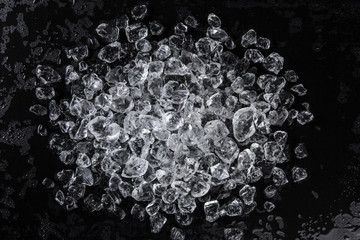 Wall Mural - pile of crushed ice on a black table. top view