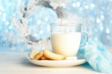 Glass mug of hot milk with cookies