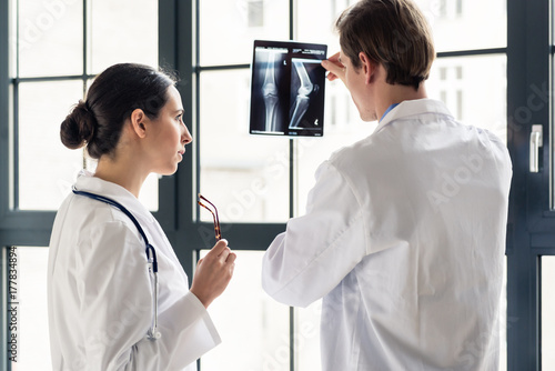 Fotografía Experienced male orthopedist helping his female colleague with the interpretatio