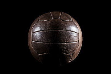 Wall Mural - Old football leather ball on a black background