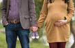 Young elegant couple expecting a baby. Pregnant mother holding hands with her husband