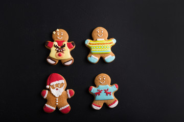 Wall Mural -  Ginger men with colored  glaze on a black background . Gingerbread. Christmas cookies.