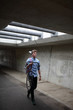 © Marcel/Stocksy - Young man walking with vintage bicycle on his shoulder in an urban bike  tunnel