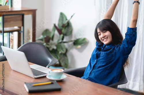 Plakat azja kobieta relaks po pracy, kobieta podnieść ramię się wyciągając przed laptopa i filiżankę kawy na stół z drewna w kawiarni restauracji, pracy styl życia poza biurem, chill out wypoczynku