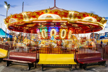 A Merry-go-round In Motion At An Amusement Park At Dusk
