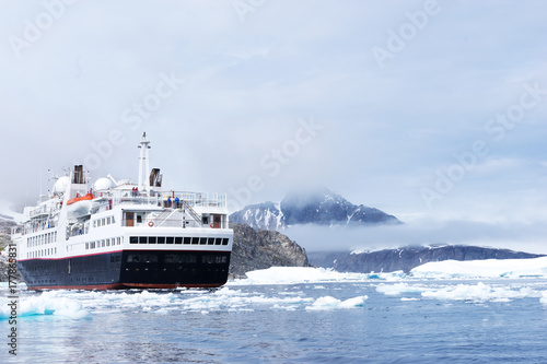 Plakat luksusowy statek pasażerski żagle na lodowatym morzu w Antarktyce w chmurach ky