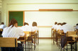 © smolaw11 - Behind girls group undergraduate students testing of examination in room and student sitting on row chair doing final exams in classroom with Thailand uniform. Asian Education Concept.