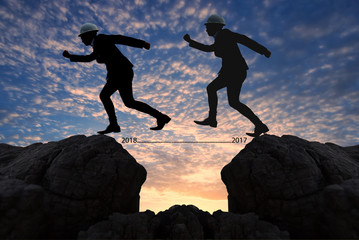 brave man successful concept,silhouette man jumping over the sun between gap of the mountain from 2017 to 2018 new year , it feel like a winner, success, finish,reach a goal of live, jobs,work.