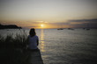 © Koen Meershoek/Stocksy - young female looking at a beautiful sunset at the adriatic sea.