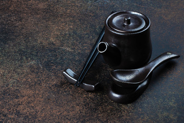 Japanese and Chinese food equipment on dark stone concrete table background. Wooden Chopsticks, kettle with soy sauce on blackboard .Top view with copy space