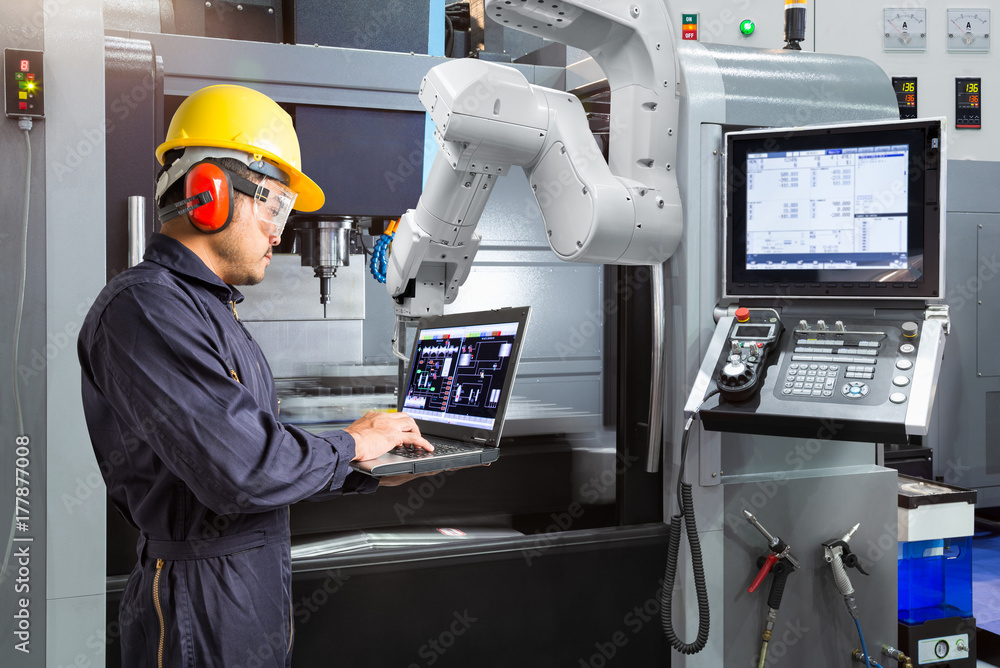 Maintenance engineer using laptop computer control automatic robotic ...