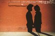 © WAVE/Stocksy - Gay couple shadow on brick wall