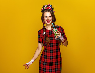 Sticker - smiling woman on yellow background with Halloween cocktail