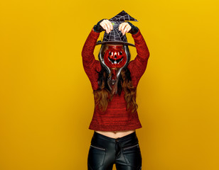 Sticker - young woman holding jack-o-lantern in front of face