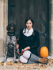 Creepy girl with dog and halloween pumpkin